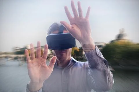 Man using a virtual reality device against river seine in paris Stock Photos