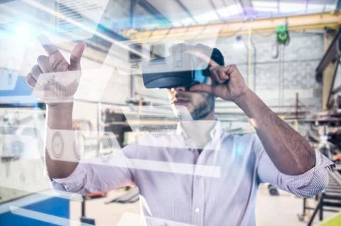 Man using a virtual reality device against workshop Stock Photos