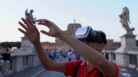 Man using virtual reality glasses on the Ponte Sant'Angelo, Rome, Italy. Technol Stock Footage 80252500