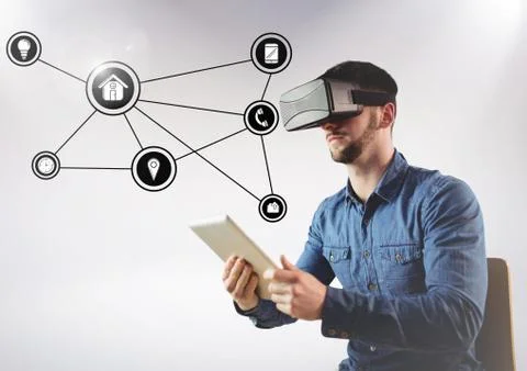 Man using virtual reality headset and digital tablet and networking icons in Stockfoto's