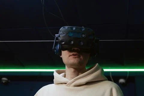 Man using virtual reality headset in dark room of vr gaming club Stock Photos