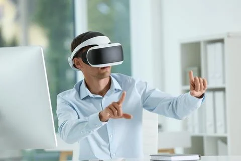 Man using virtual reality headset in office Stock Photos