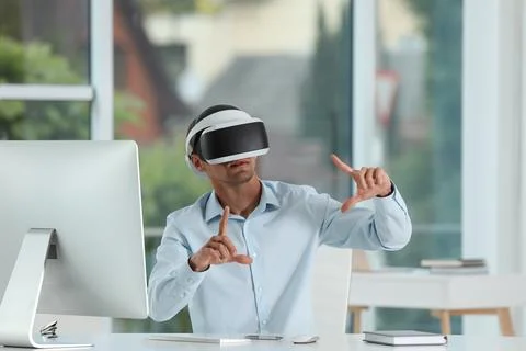 Man using virtual reality headset in office Stock Photos