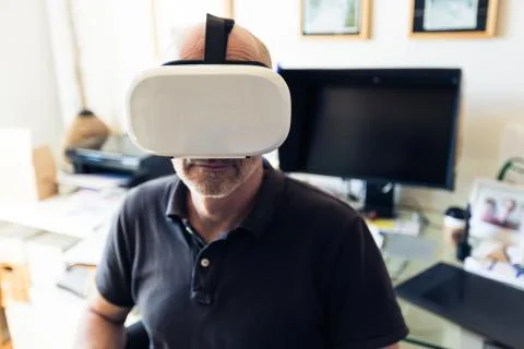 Man Using Vr Goggles In His Office, Working At Computer Foto stock