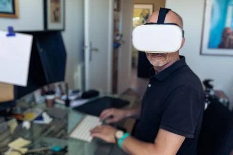 Man Using Vr Goggles In His Office, Working At Computer Foto stock