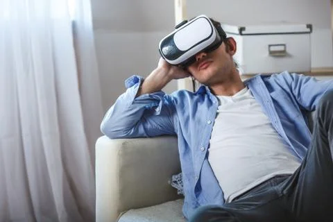 Man using VR headset on couch Stock Photos