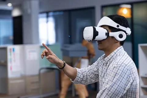 Man using VR headset in modern office, interacting with virtual environment Fotos de archivo