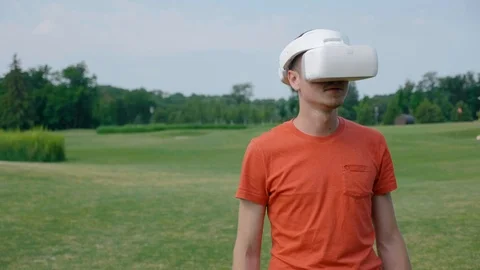 A man using a VR headset in the park and turns his head to the left Stock Footage 112807773