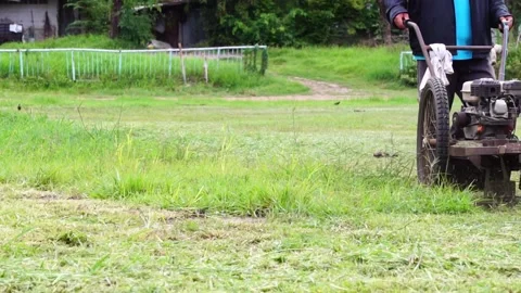 Man using a walk-behind lawnmower on a football field. Stock Footage 169245711