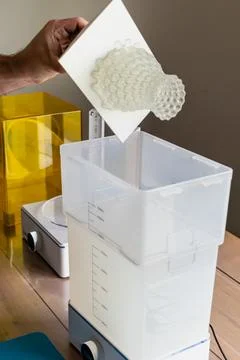 Man using a wash machine to clean a transparent 3d resin object Stock Photos