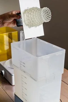 Man using a wash machine to clean a transparent 3d resin object 库存照片