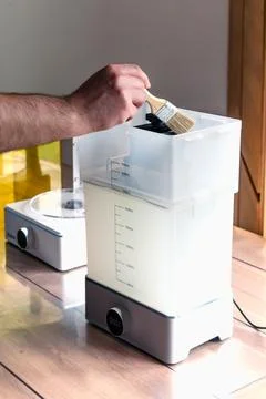 Man using a wash machine to clean a transparent 3d resin object Foto stock