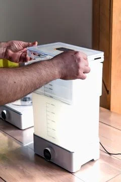 Man using a wash machine to clean a transparent 3d resin object Foto stock