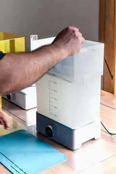 Man using a wash machine to clean a transparent 3d resin object Foto stock