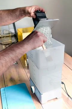 Man using a wash machine to clean a transparent 3d resin object Foto stock