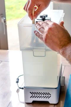 Man using a wash machine to clean a transparent 3d resin object Foto stock