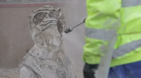Man using a water pressure hose to remove clay from a bronze statue Stock Footage 58642168