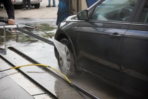 Man Using Water Pressure Machine to Wash a Car on Blurred Background-18 Stock Photos
