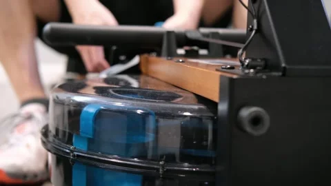 Man using a water rowing machine for exercise Stock Footage 329649789