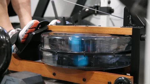 Man using a water rowing machine for exercise Stock Footage 329649796