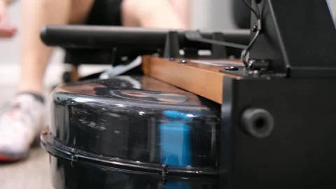 Man using a water rowing machine for exercise Stock Footage 329649815