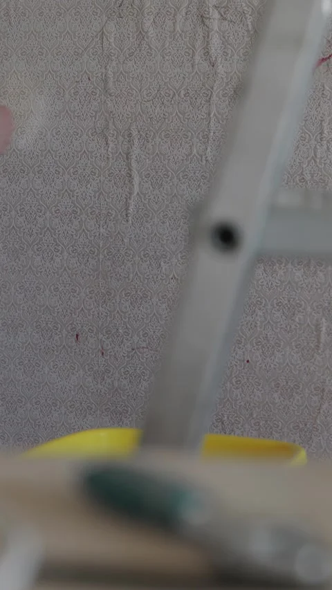 Man using wet roller brush to soften stubborn old wallpaper 스톡 동영상 338003359