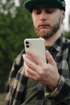 Man using white smartphone on blurred nature background, close up. Foto stock