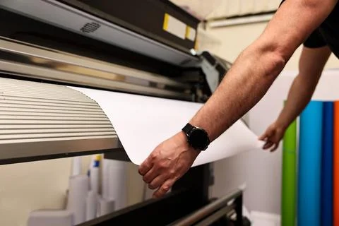 Man using wide-format printer indoors, closeup. Printing house Foto stock