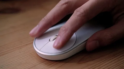 Man Using a Wireless Computer Mouse on a wooden surface, clicking and scrolling. Stock Footage 100403551