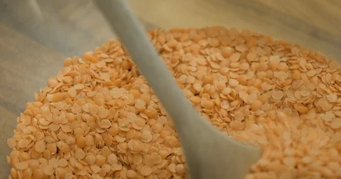 Man using a wooden cooking spoon to check lentil quality Stock Footage 99952524