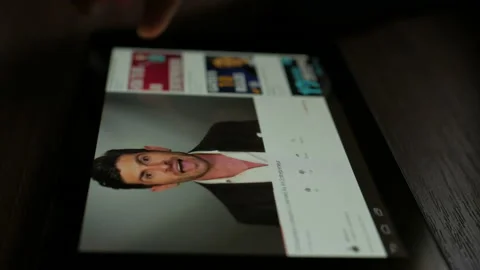 Man using youtube app on tablet computer device, scrolling videos, tapping on Stock Footage 88957902