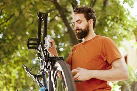 Man utilizing lubricant on bicycle 写真素材
