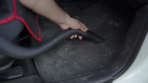 A man is vacuuming the floor of a car. Stock Footage 313681971