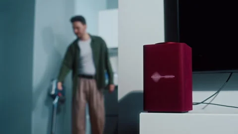 Man vacuuming floor while music plays from smart speaker Video stock 319442270