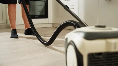 A man is vacuuming the kitchen. Stock Footage 282283186