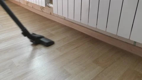 Man vacuums the floor in the room Stock Footage