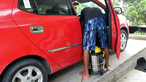 A man vacuums the inside of a car  Stock Footage 232388818
