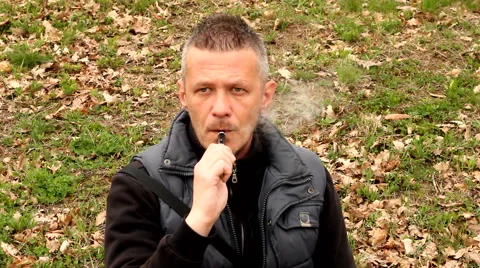 Man vaping e cigarette outdoor in the field Stock Footage 48941158