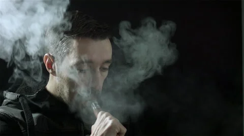 Man vaping with an electronic cigarette and make some smoke clouds (vapor) Stock Footage 62604007