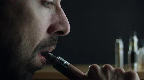 Man vaping with an electronic cigarette and make some smoke clouds (vapor) Stock Footage 62605770