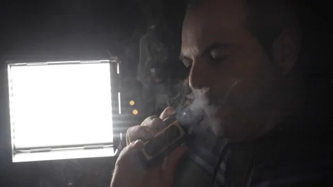 Man vaping electronic cigarette at night with illuminated city background Stock Footage 116508384