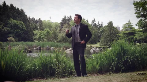 Man vaping electronic cigarette in Park Stock Footage 64454608