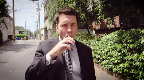 Man vaping electronic cigarette in street Stock Footage 64455008