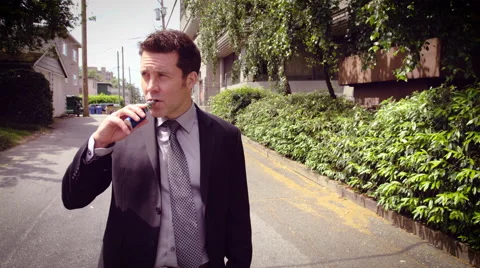 Man vaping electronic cigarette on the street Stock Footage 64455043