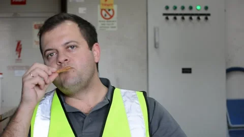 Man in vest eats slice of pizza on workplace Vídeo Stock 143452187