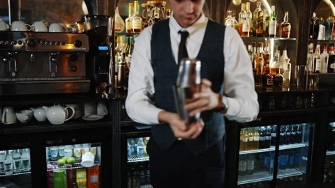 A man in a vest is making a drink at a bar Stock Footage 295996010