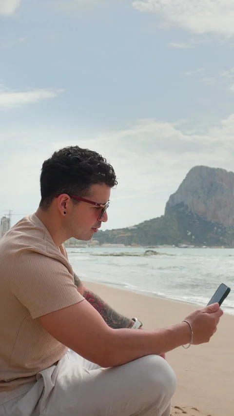 Man on video call expressing frustration remote beach work 動画素材 333690547