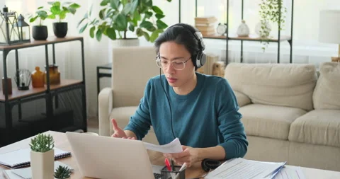 Man video conferencing using laptop and headphones Stock Footage 145293372