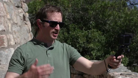 A man video vlogging in an outdoor setting Stock Footage 238007110