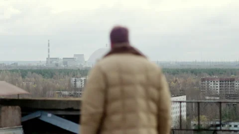 Man viewing Chernobyl nuclear power plant from Pripyat rooftop Stock-Footage 332829527